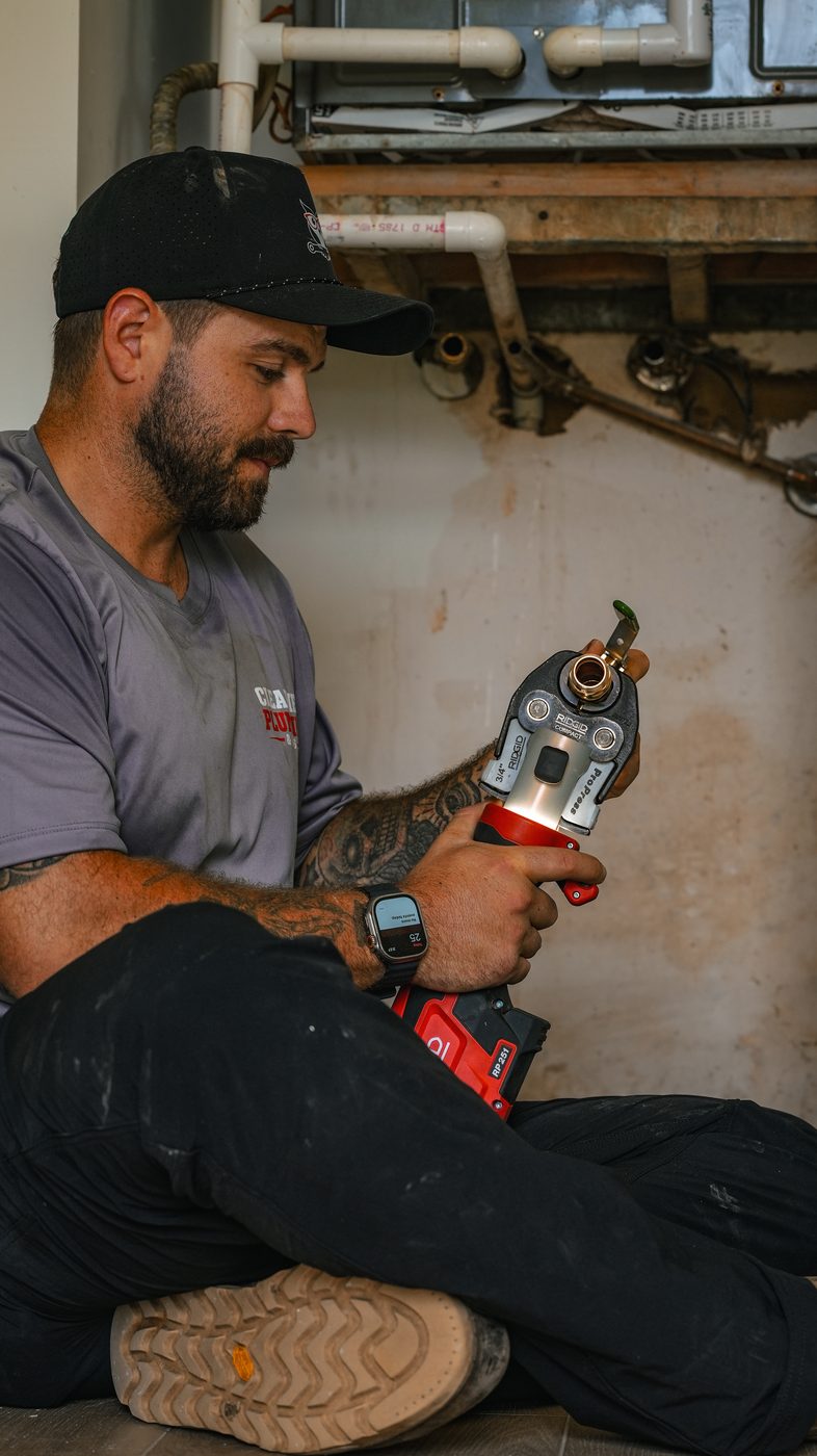 Clearview plumber using a ProPress tool during a water heater installation