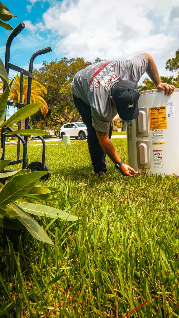 Plumber checking a water heater valve for leaks in Delray Beach