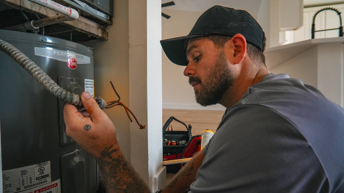 Licensed plumber checking a water heater during a service call